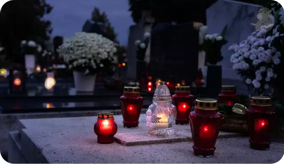 czerwone znicze ustawione w przemyślany sposób na pomniku zmarłego